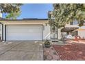 Welcoming front entrance with a paved walkway, cozy porch swing, and a two-car garage at 15531 E Jewell Pl, Aurora, CO 80013