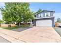Charming two-story home with a well-manicured lawn, mature trees, and an attached two-car garage at 8977 W Toller Ave, Littleton, CO 80128