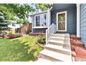 Inviting front entrance with well-maintained lawn, flower beds, and charming exterior details at 8977 W Toller Ave, Littleton, CO 80128