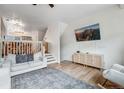 Spacious living room with a TV, stylish console, and stairs leading to the next level at 12063 Monaco Ct, Brighton, CO 80602