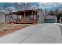 Exterior view of home showing driveway and garage, complimented by mature trees and nice green space at 3290 S Holly St, Denver, CO 80222