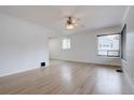 Bright living room with hardwood floors, neutral paint, ceiling fan and large windows offering great natural light at 3290 S Holly St, Denver, CO 80222