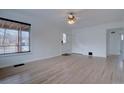 Spacious living room with hardwood floors, closet, ceiling fan and freshly painted walls at 3290 S Holly St, Denver, CO 80222