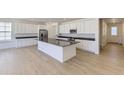 Beautiful kitchen with stainless steel appliances, an island with black countertops, and white cabinets at 39867 Floyd St, Elizabeth, CO 80107