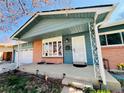 Inviting front porch with a storm door, brick accents, and blue wood siding at 2964 S Yates St, Denver, CO 80236