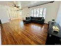 Bright living room with hardwood floors, large windows, and custom built-in shelving at 2964 S Yates St, Denver, CO 80236