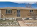 Well-maintained brick home featuring a secure screen door and landscaped front yard at 1781 Uinta St, Denver, CO 80220