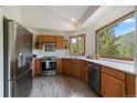 This kitchen features wood cabinets, stainless steel appliances, and a large window at 960 Aspen Pl, Evergreen, CO 80439