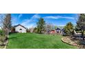 Expansive backyard with lush green grass, mature trees, and a well-maintained wooden fence at 2912 Lake Park Way, Longmont, CO 80503