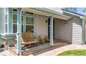 Inviting porch area with comfortable wooden chairs, perfect for enjoying the outdoors and relaxing with guests at 13323 Birch Cir, Thornton, CO 80241