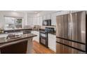 Modern kitchen featuring stainless steel appliances, granite countertops, and hardwood floors at 8825 Fairview Oaks Pl, Lone Tree, CO 80124