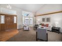 The bright living room is a comfortable space featuring a large window and vaulted ceiling at 8825 Fairview Oaks Pl, Lone Tree, CO 80124