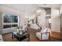 A welcoming living room showcases vaulted ceilings, a large window, and an adjacent staircase at 8825 Fairview Oaks Pl, Lone Tree, CO 80124