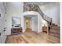 Open foyer with hardwood floors, a staircase with iron railing, and a decorative chandelier at 6074 S Oswego St, Greenwood Village, CO 80111