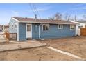 Home back exterior featuring blue siding, a small brick patio, and a practical entrance at 4211 E 69Th Ave, Commerce City, CO 80022