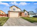 Inviting two-story home with a two-car garage and spacious driveway, set against a sunny sky at 4014 S Kirk Way, Aurora, CO 80013