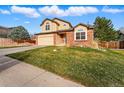 Suburban home with well-kept lawn, two-car garage, and traditional architecture under a bright sky at 4014 S Kirk Way, Aurora, CO 80013