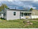 View of the front of this charming home, showcasing its lovely yard, solar panels and covered porch at 98 N 12Th Ave, Brighton, CO 80601