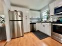 Bright kitchen featuring stainless steel appliances, white cabinets, and wood-look flooring at 98 N 12Th Ave, Brighton, CO 80601