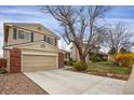 Traditional two-story home boasting an attached garage, neutral siding, brick accents, and a paved driveway at 8441 Timberwood St, Littleton, CO 80126