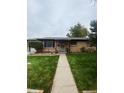 Charming brick home with well-maintained front yard and covered entry at 3000 Billings St, Aurora, CO 80011