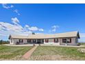 Expansive single-story home featuring red shutters, a metal roof, and a manicured front lawn at 30999 Kootney St, Elizabeth, CO 80107
