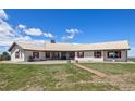 Lovely exterior of single-story home showing red shutters, a metal roof, and a spacious front lawn at 30999 Kootney St, Elizabeth, CO 80107