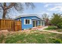 Blue home with white trim and privacy fence, creating a cozy outdoor space at 6445 Second St, Louviers, CO 80131