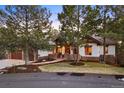 Inviting home with stone accents, lush lawn, mature trees, and a warm, welcoming atmosphere at 646 Ruby Trust Dr, Castle Rock, CO 80108