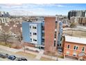 View of the building with blue and gray panels nestled in an urban landscape and cityscape at 2460 W 29Th Ave # 204, Denver, CO 80211