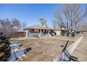 Lovely single-story home with a well-maintained lawn, partially snow-covered, and a quaint fence outlining the property at 5895 S Huron St, Littleton, CO 80120