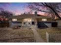 Charming home exterior with a manicured lawn, fenced yard, and inviting front porch, showcasing curb appeal and modern accents at 5895 S Huron St, Littleton, CO 80120