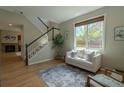 Bright living room with hardwood floors, a staircase, a fireplace, and natural light from a large window at 2908 Open Sky Way, Castle Rock, CO 80109