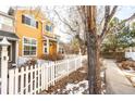 Inviting townhome exterior with a charming white picket fence at 911 Snowberry St, Longmont, CO 80503