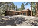 Charming single story house with gravel driveway, wood siding, and an attached two car garage at 8782 S Ault Ln, Morrison, CO 80465