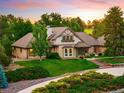 Charming home with brick and stone exterior, lush green lawn, and mature trees at sunset at 17053 E Jamison Ave, Centennial, CO 80016