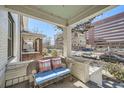 Relaxing front porch seating area with a comfortable wicker bench and colorful pillows at 636 N Logan St, Denver, CO 80203