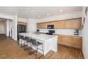 Modern kitchen with island, stainless steel appliances, and light wood cabinets at 27840 E 7Th Pl, Aurora, CO 80018