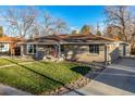 Landscaped front yard features a well-manicured lawn, rock details, and an inviting facade at 5500 Holland Dr, Arvada, CO 80002