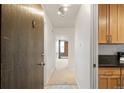 Apartment entryway featuring a wooden door, neutral carpet, and view of the living room at 850 20Th St # 201, Boulder, CO 80302