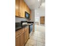Kitchen featuring wood cabinets, black granite countertops, tile flooring, and stainless appliances at 850 20Th St # 201, Boulder, CO 80302