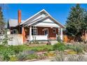 Attractive brick home with a well-maintained yard and front porch, enhanced by colorful flowerbeds at 3725 S Acoma St, Englewood, CO 80110