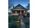 Quaint home with a welcoming porch, featuring soft exterior lighting and a landscaped front yard at 3725 S Acoma St, Englewood, CO 80110