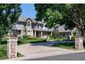 Charming two-story home with brick and siding exterior, featuring a circular driveway and manicured landscaping at 4845 S Gaylord St, Cherry Hills Village, CO 80113
