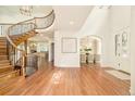Welcoming foyer featuring a sweeping staircase, hardwood floors, and entry to the formal dining room at 4845 S Gaylord St, Cherry Hills Village, CO 80113