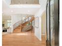 Bright foyer with a winding staircase, hardwood floors, and open access to the living area at 4845 S Gaylord St, Cherry Hills Village, CO 80113