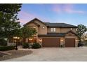 Charming home featuring stone accents, a spacious three-car garage, and manicured landscaping at 7465 Kelty Trl, Franktown, CO 80116