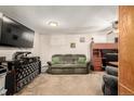 Cozy living room with neutral carpet, ceiling fan, and olive green sofa at 902 S Yukon St, Lakewood, CO 80226