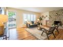 Cozy living room with a decorative stone fireplace, hardwood floors, and bright natural light at 2744 S Newton Way, Denver, CO 80236