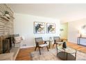 Bright living room with a stone fireplace, hardwood flooring, and contemporary furnishings at 2744 S Newton Way, Denver, CO 80236